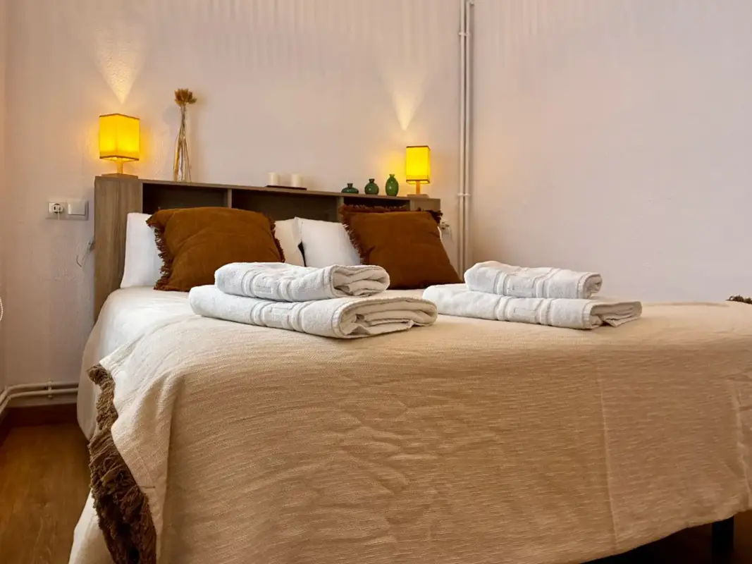 Cama doble con toallas en Apartamentos Villa García