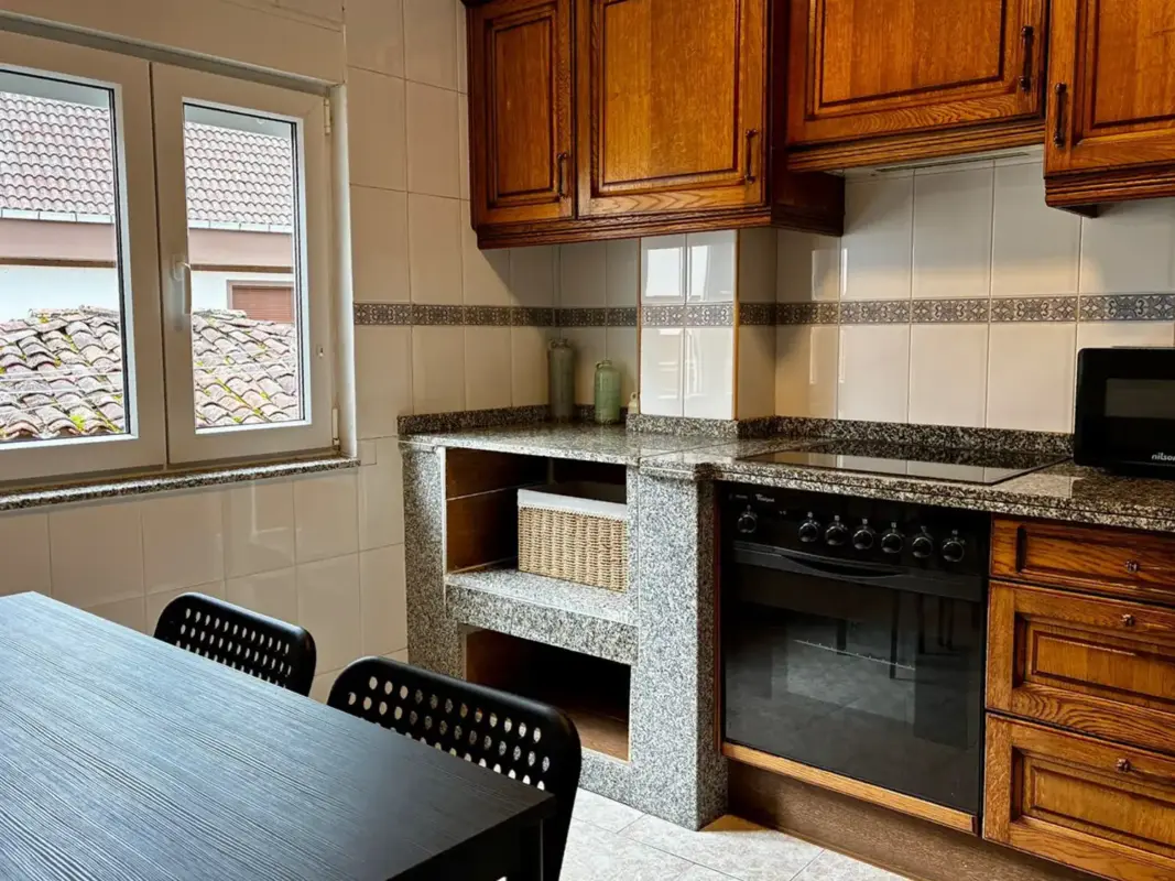 Cocina comedor con horno y mesa en Apartamentos Villa García