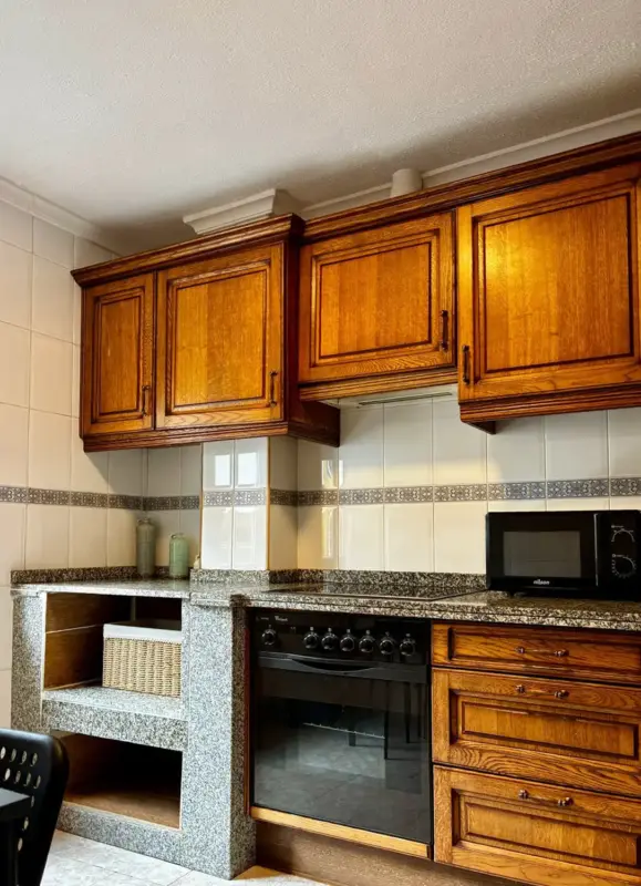 Cocina equipada con muebles de madera en Apartamentos Villa García