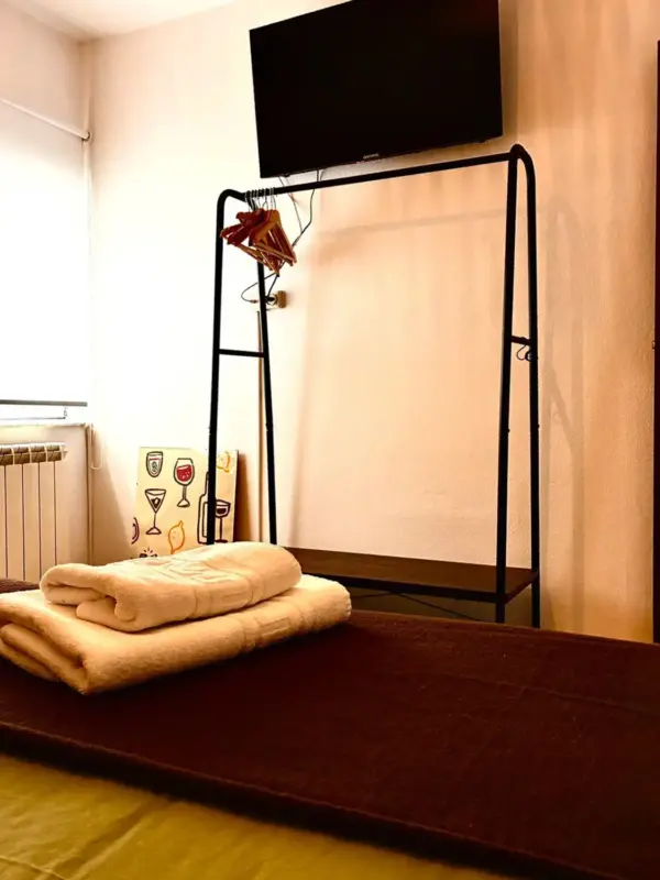 Dormitorio con perchero y toallas preparadas en Apartamentos Villa García